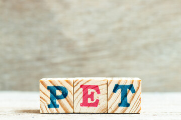 Alphabet letter block in word PET (animal or abbreviation of polyethylene terephthalate) on wood background