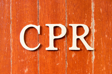 Alphabet letter in word CPR (abbreviation of Cardiopulmonary resuscitation) on old red color wood plate background - obrazy, fototapety, plakaty