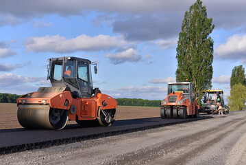 Obraz na płótnie Canvas roller laying fresh asphalt . Road works with excavators. Construction of new roads on the highway in the field 
