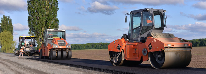 roller laying fresh asphalt . Road works with excavators. Construction of new roads on the highway...