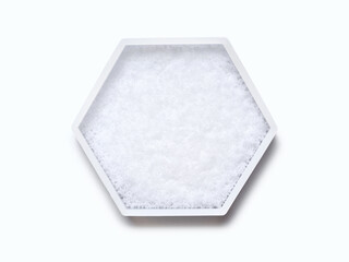 Sodium Hydroxide Pellets in hexagonal molecular shaped container on white background. Top View