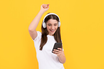 happy woman listen music in earphones with smartphone on yellow background, music