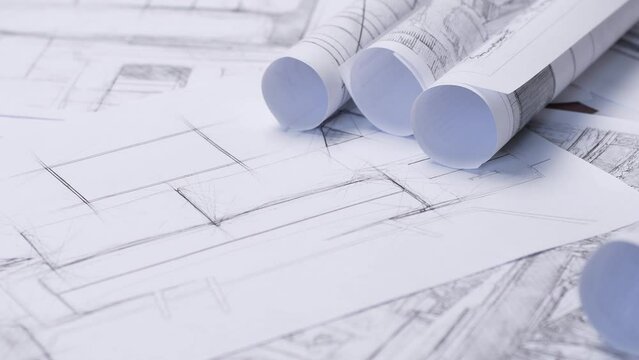 Background on the theme of business in the field of construction and architecture. Sheets with drawings and sketches of the interior of a living room with a sofa