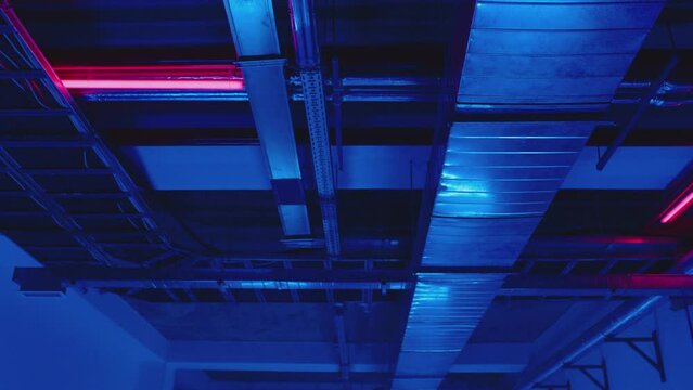 4K Electrical and air systems communications with cables and metal pipes inside modern building , parking or factory  . Concept of electric construction equipment . Communication under ceiling .