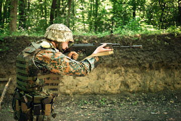 The Ukrainian military in a bulletproof vest shoots from the machine gun