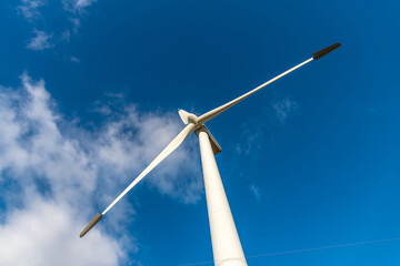 View of the blades of a wind turbine with blue sky in the background. Renewable energy concept