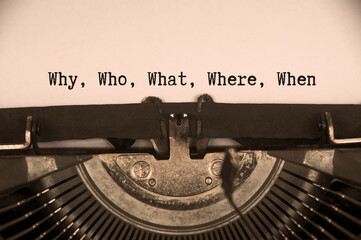 Why, who, what, where and when text on an old typewriter.