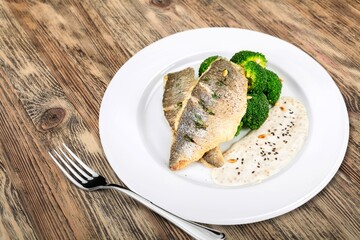 Fried fish with vegetable and salad on ceramic plate