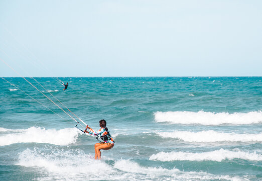 Joven surfera disfrutando haciendo kite surf en la playa. 