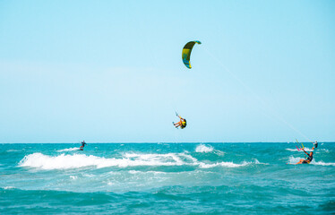 Acción de deportes acuáticos recreativos. Surferos dando saltos sobre las olas en el mar,...