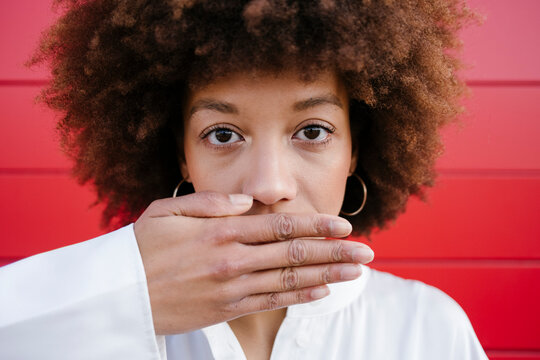 Young woman covering mouth with hand