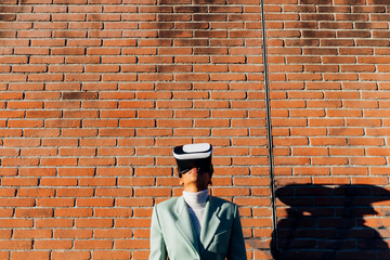 Businesswoman watching on VR goggles in front of wall