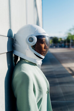 Businesswoman wearing space helmet on sunny day