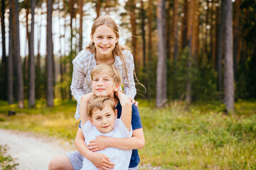 Fototapeta premium Teaching child to love nature, summer camping concept. Teenage friends having fun at summer forest in nature.