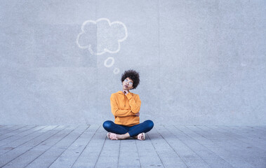 Woman sitting cross-legged on ground with empty thought bubble
