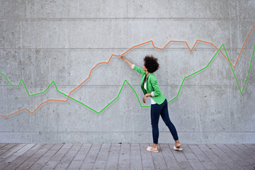Young woman pointing at chart painted on wall