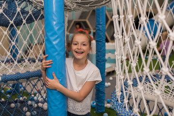 little happy girl playing in the amusement park in the mall, children's fun games and entertainment