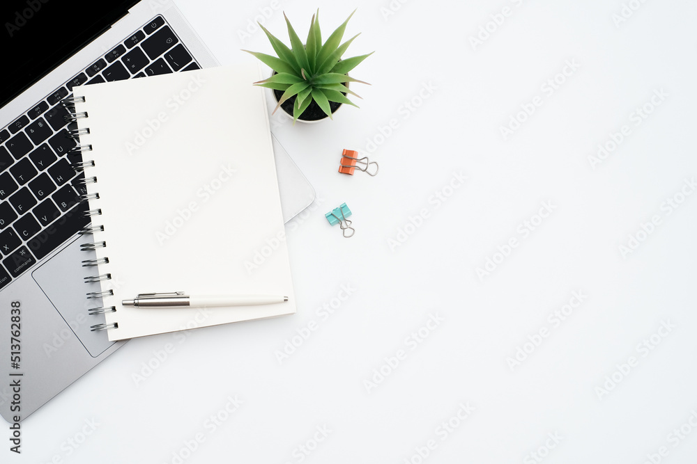 Wall mural blank white notepad on laptop computer with stationery on white table desk background with copy spac