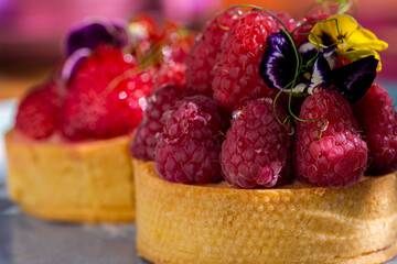 Cupcake with flower petals, strawberries, raspberries and cream