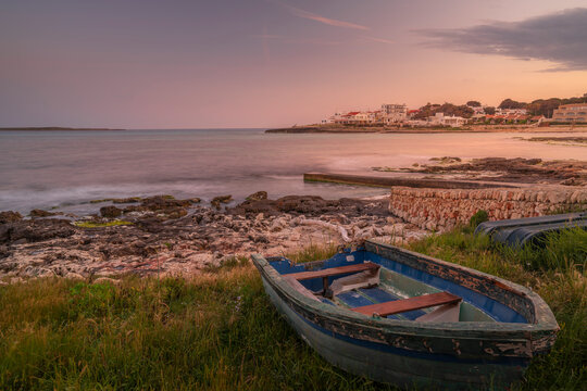 View of Playa Punta Prima and rowing boat at dusk, Punta Prima, Menorca, Balearic Islands