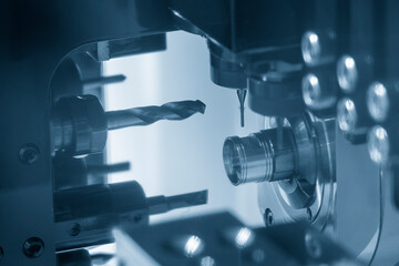 The multi-tasking CNC lathe machine swiss type hole drilling on the metal parts.