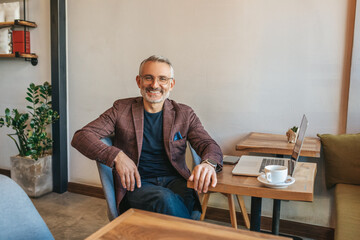 Man sitting at table smiling at camera