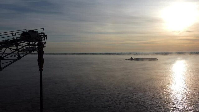 Aerial view from the drone, the boat sails on the river in the morning, the fog and the sun complete the image