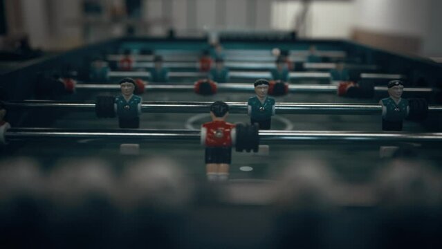 Miniature foosball players figures on table close up. Teenagers entertainment.