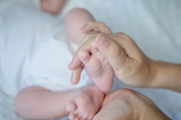 Mother hand holding feet baby infant closeup, Family newborn baby relationship