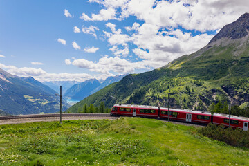 red train at the Alpe Grum station towards the Bernina Pass, Switzerland
