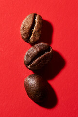 Roasted coffee beans isolated close up on red background, clipping path