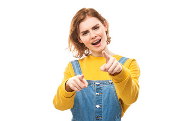 Portrait of friendly redhead girl chooses you, points finger at the camera isolated on white background