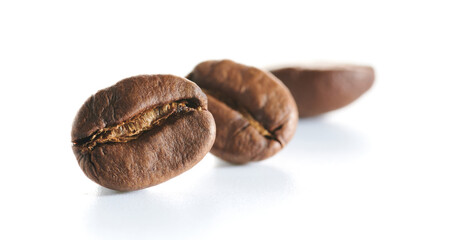 Roasted coffee beans isolated close up on white background, clipping path