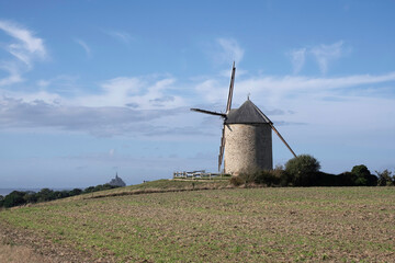 Windmill on a top of a hill with Mont Saint Michel in the backround, Normandy, France