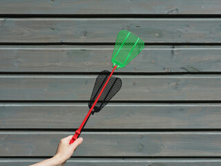 Plastic fly swatter. Insect, fly, mosquito, wasp, pest control. Hand with fly swatter