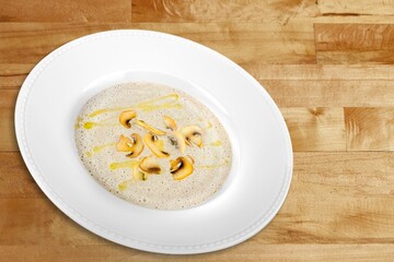 Soup in brown bowl on stone table.
