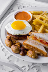 Fried eggs with cutlet and sandwiches