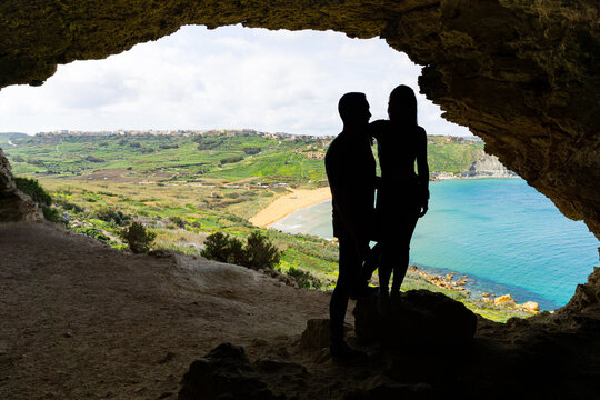Tourist couple posing hugging each other at Tal Mixta Cave in Gozo, Malta