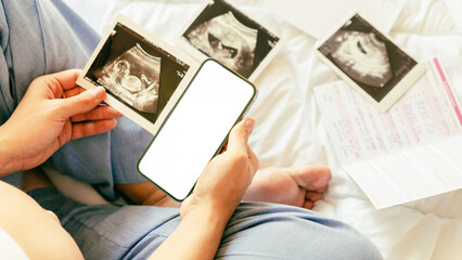 Pregnancy mockup display. Pregnant woman holding smartphone. Mobile pregnancy online maternity...