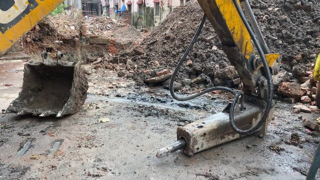 Close up video of construction equipment from JCB, tata hitachi and doosan clearing up the broken rocks from a landslide.