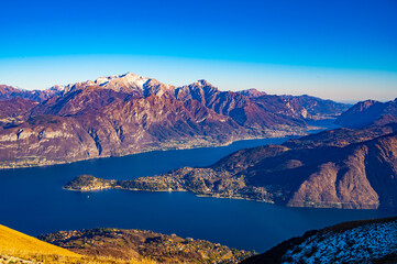 Naklejka premium The panorama of Lake Como, photographed from Monte di Tremezzo, showing the Northern Grigna, the Southern Grigna, the Lecco branch, the town of Bellagio, and the surrounding mountains.