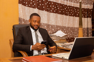 a young african business man using his credit card and mobile phone, online banking concept