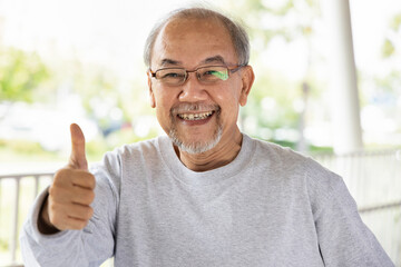 Happy smiling old senior man showing approving thumb up hand gesture