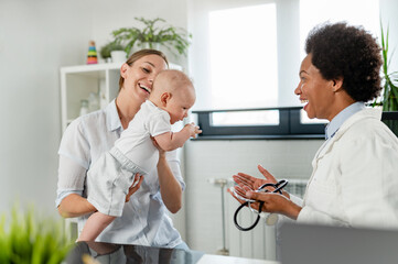 Obraz premium The consultant pediatrician with the baby patient and mother
