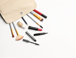 Make up products. Lipstick, powder, shadows with cosmetic bag. Image with copy space. White background