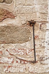 Ancient door hook with trace on stone wall.