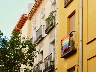 Fototapeta na wymiar Colourful buildings with rainbow flag of gay community on the balcony. Symbol of support for LGBTQ people