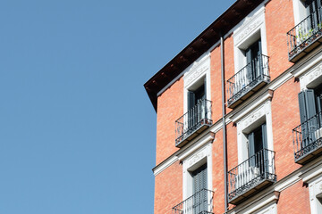 Corner of classical building made of red brick in downtown district of Madrid, Spain