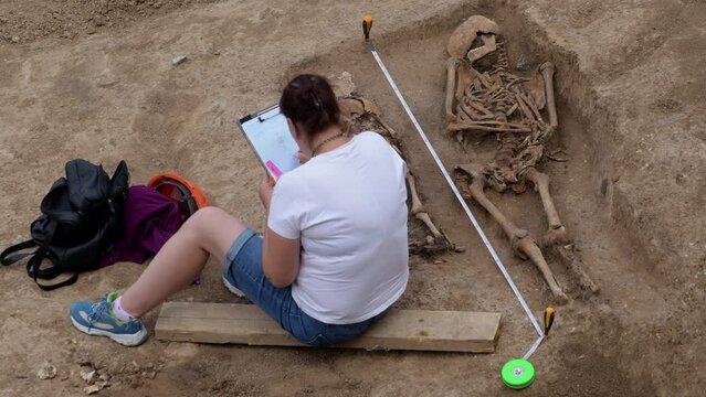 Young archeologist works on an archaeological site at morning sun rays at summer heat