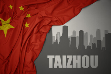 abstract silhouette of the city with text Taizhou near waving national flag of china on a gray background.